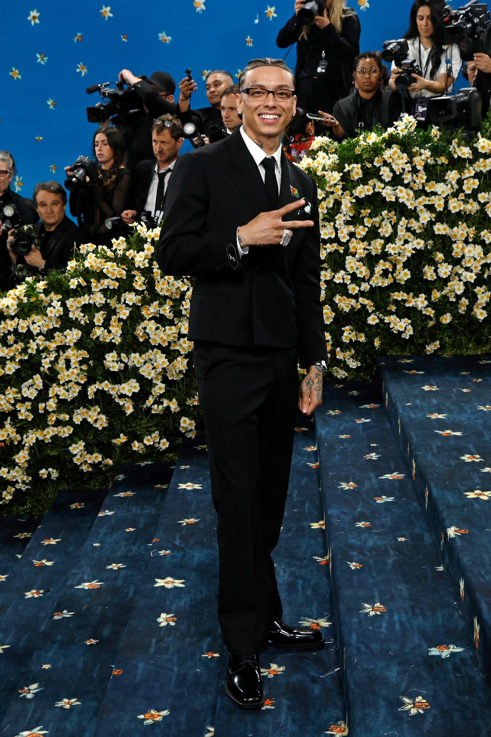 Images may contain rod square adult clothing shoes shoes shoes formal wear tie and camera