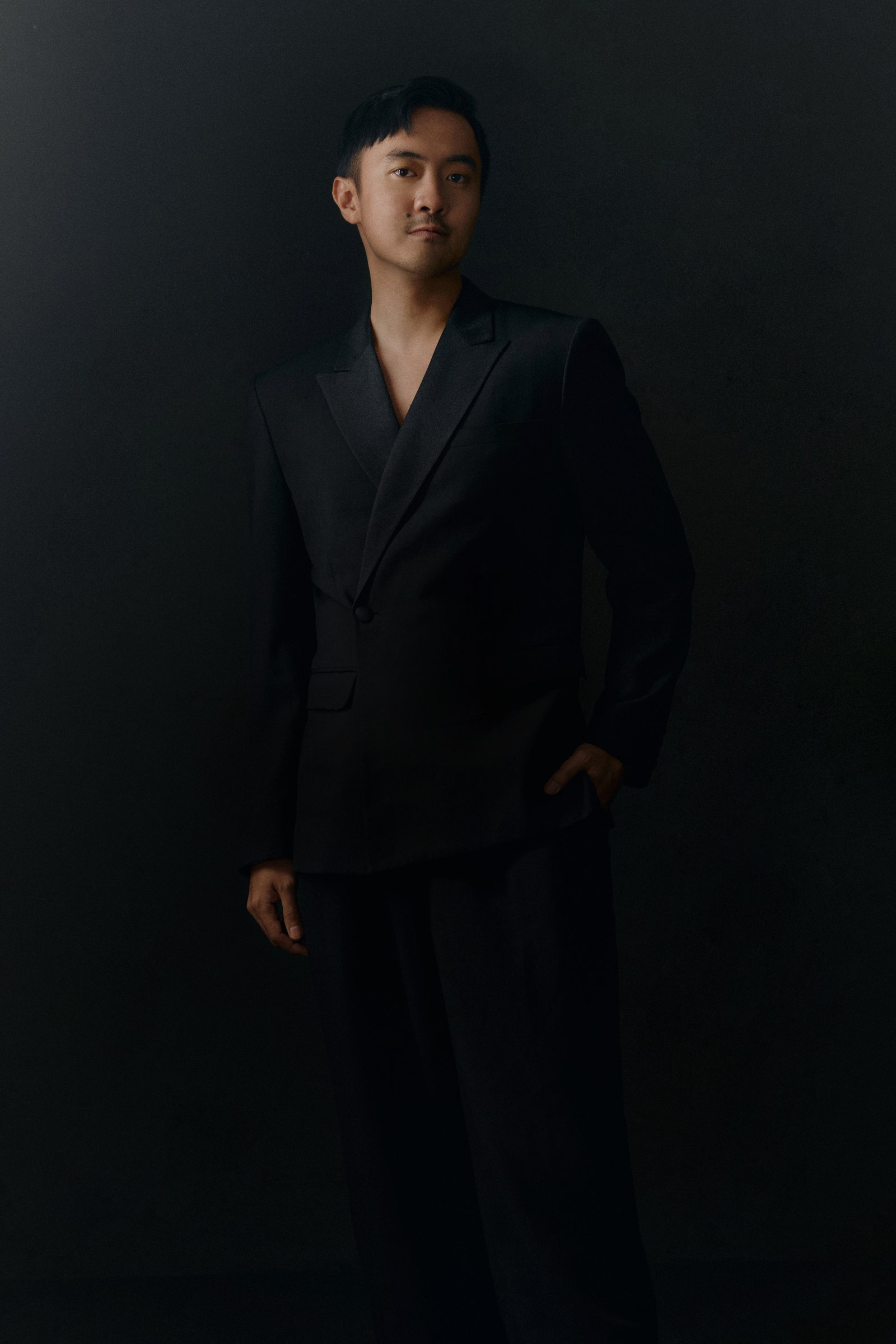 Image may contain Clothing Formal Wear Suit Tuxedo Coat Adult Person Standing Face Head Photography and Portrait