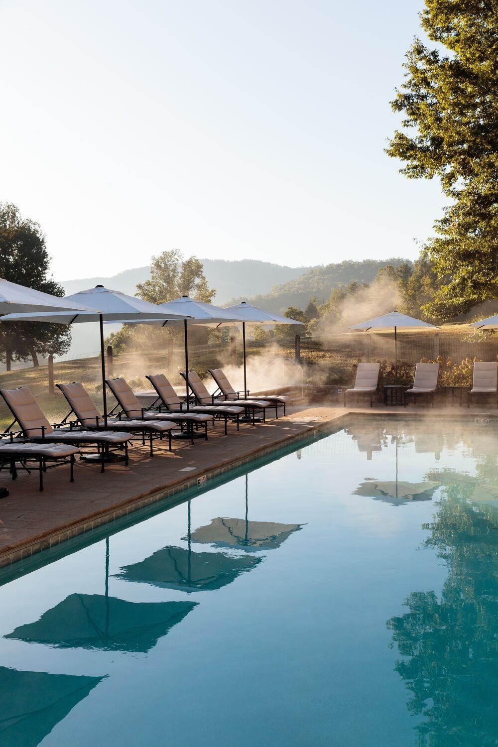 Images may contain architecture hotel vacation chair furniture pool outdoor and landscape