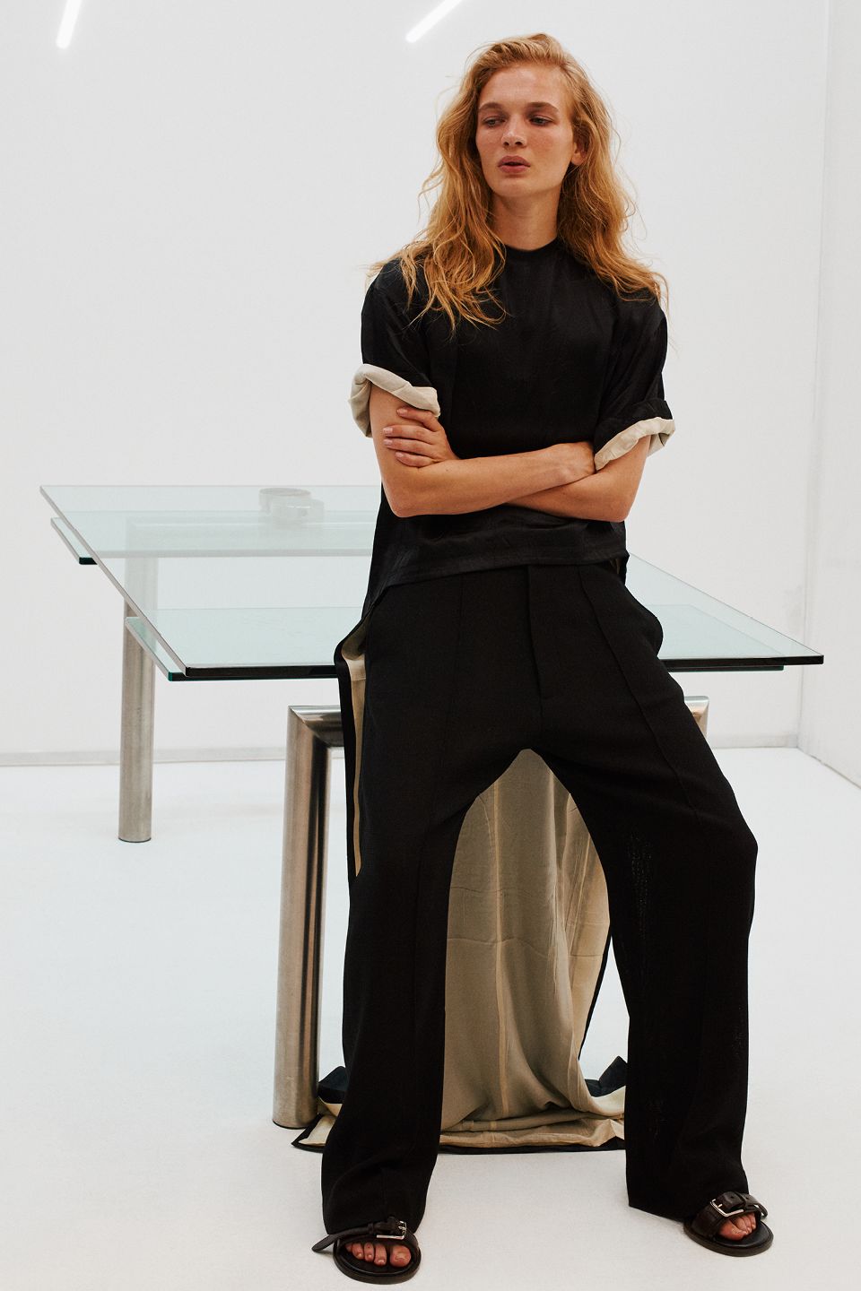 Images may contain furniture table adult sitting table clothes sandals formal wear and pants
